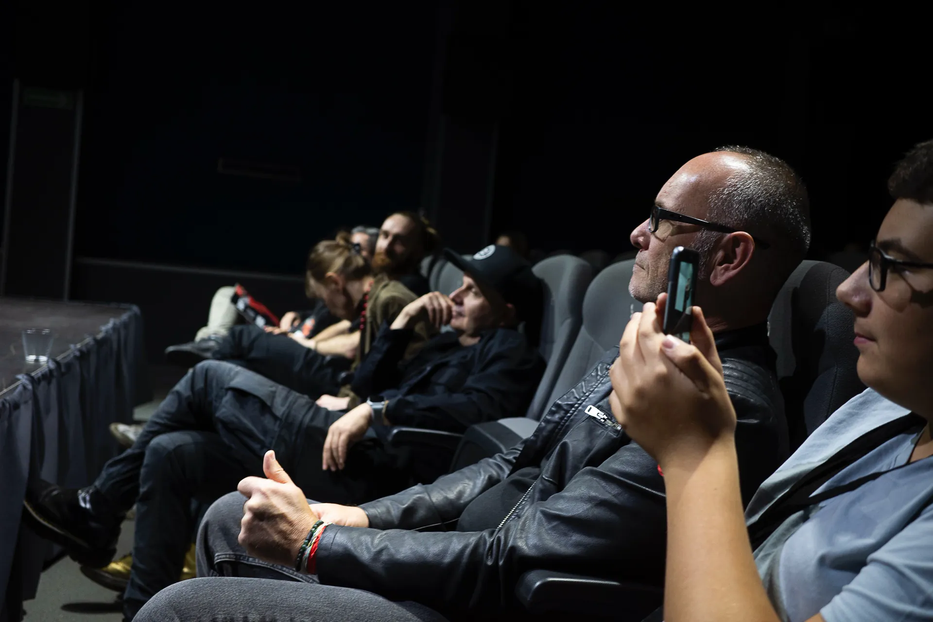 Audience members watching the screening, seen from the side