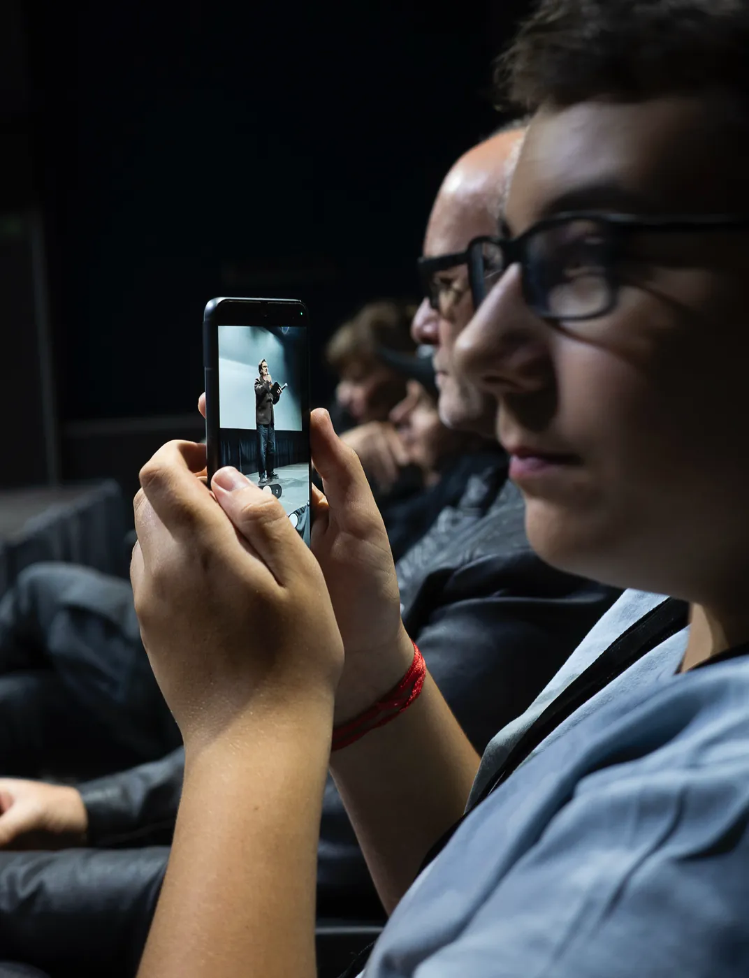 A viewer filming the stage with a phone